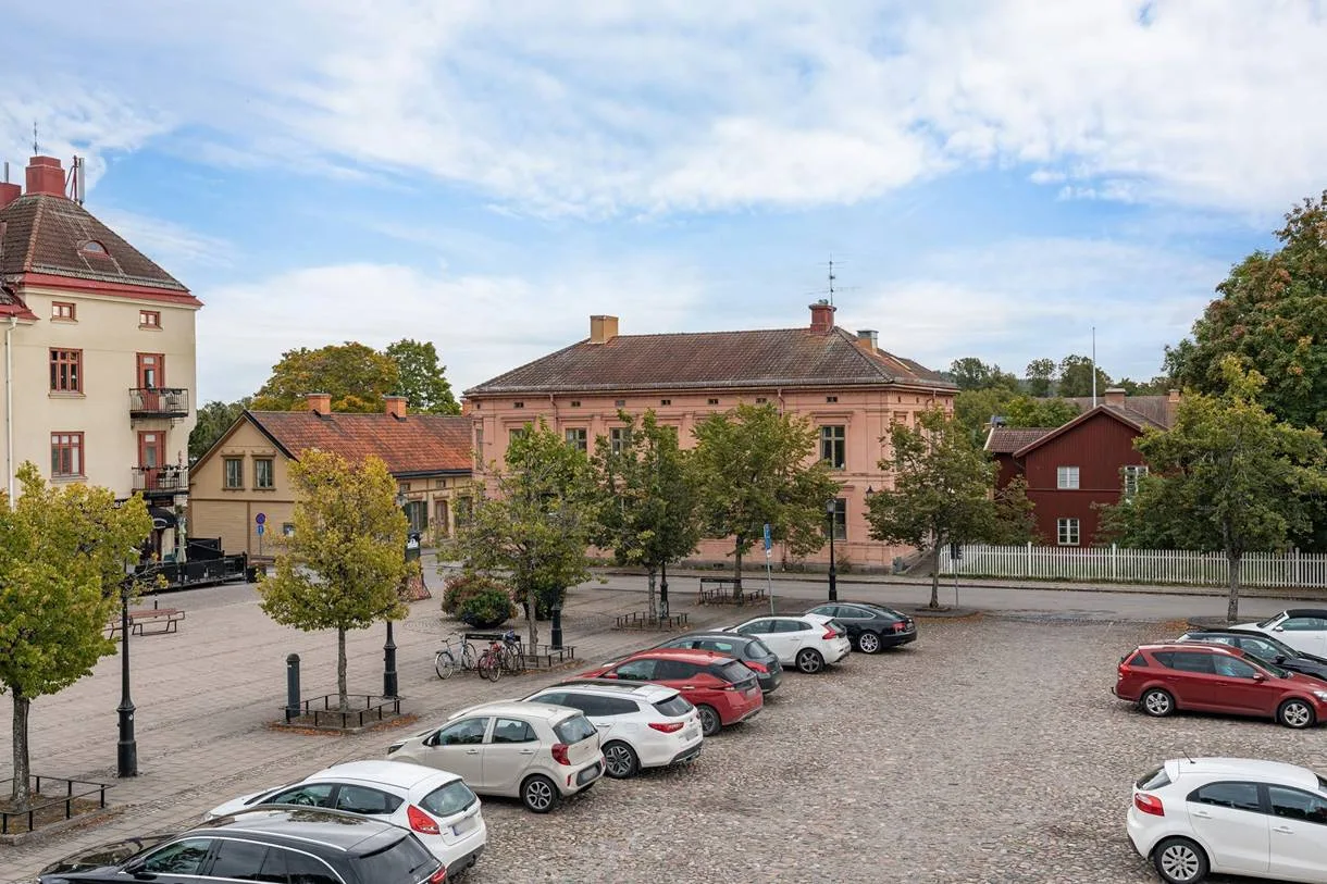Utsikt över torget i Nora mot det rosa hörnhuset