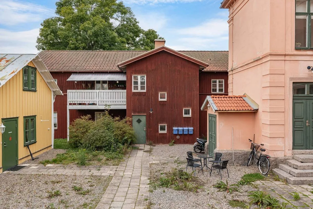 Innergården med det röda och det gula trähuset, uteplatser och cykelställ